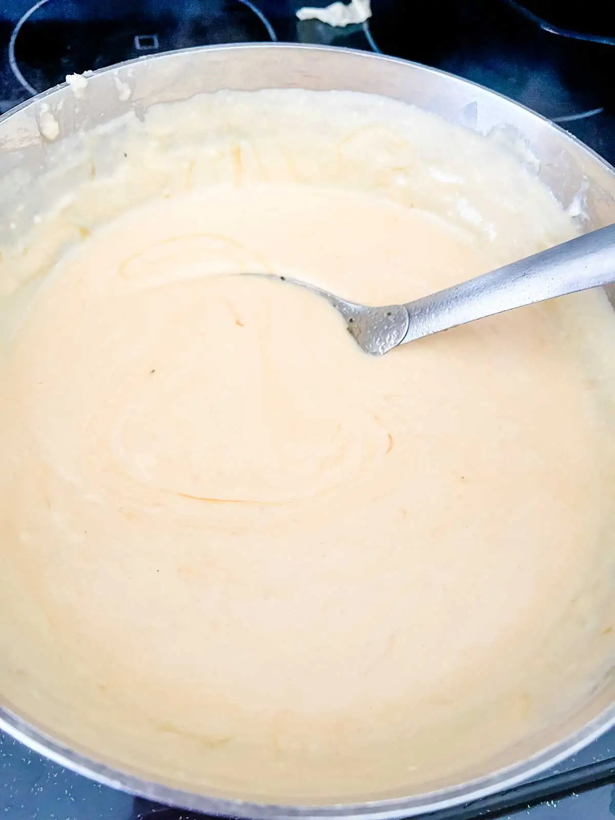 Photo of a cheese sauce in a large saucepan.
