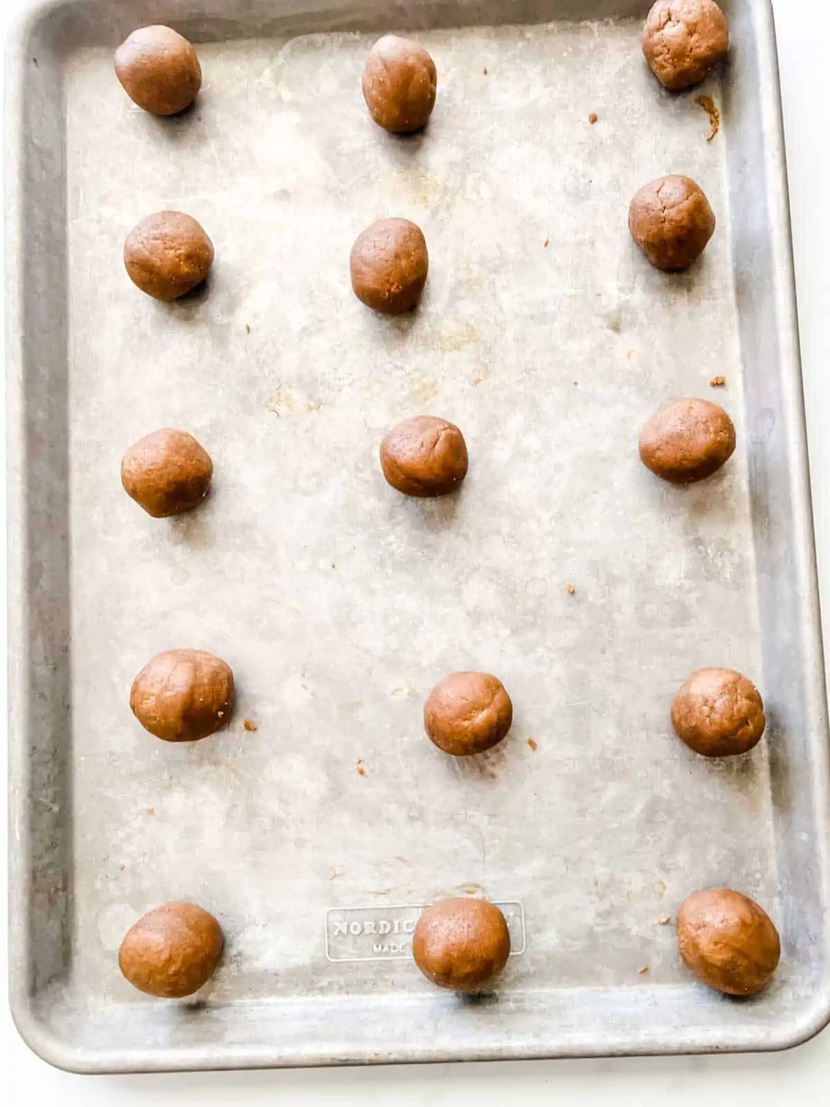 Cookies in a ball on a baking sheet.