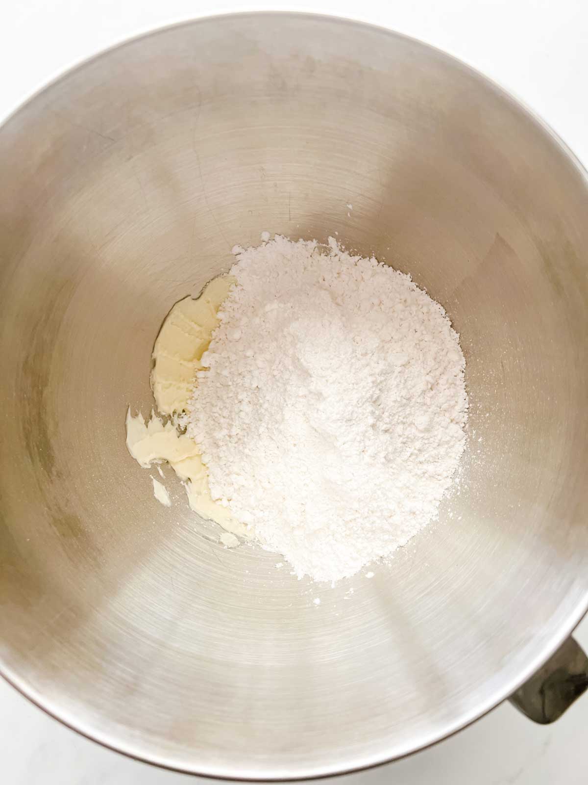 Creamed butter and powdered sugar in the bowl of a stand mixer.