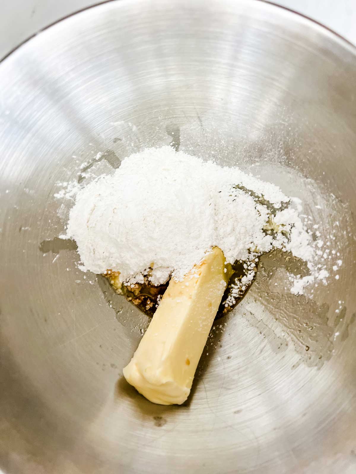 Butter, confectioner's sugar, vanilla, and peppermint extract in the bowl of a stand mixer.
