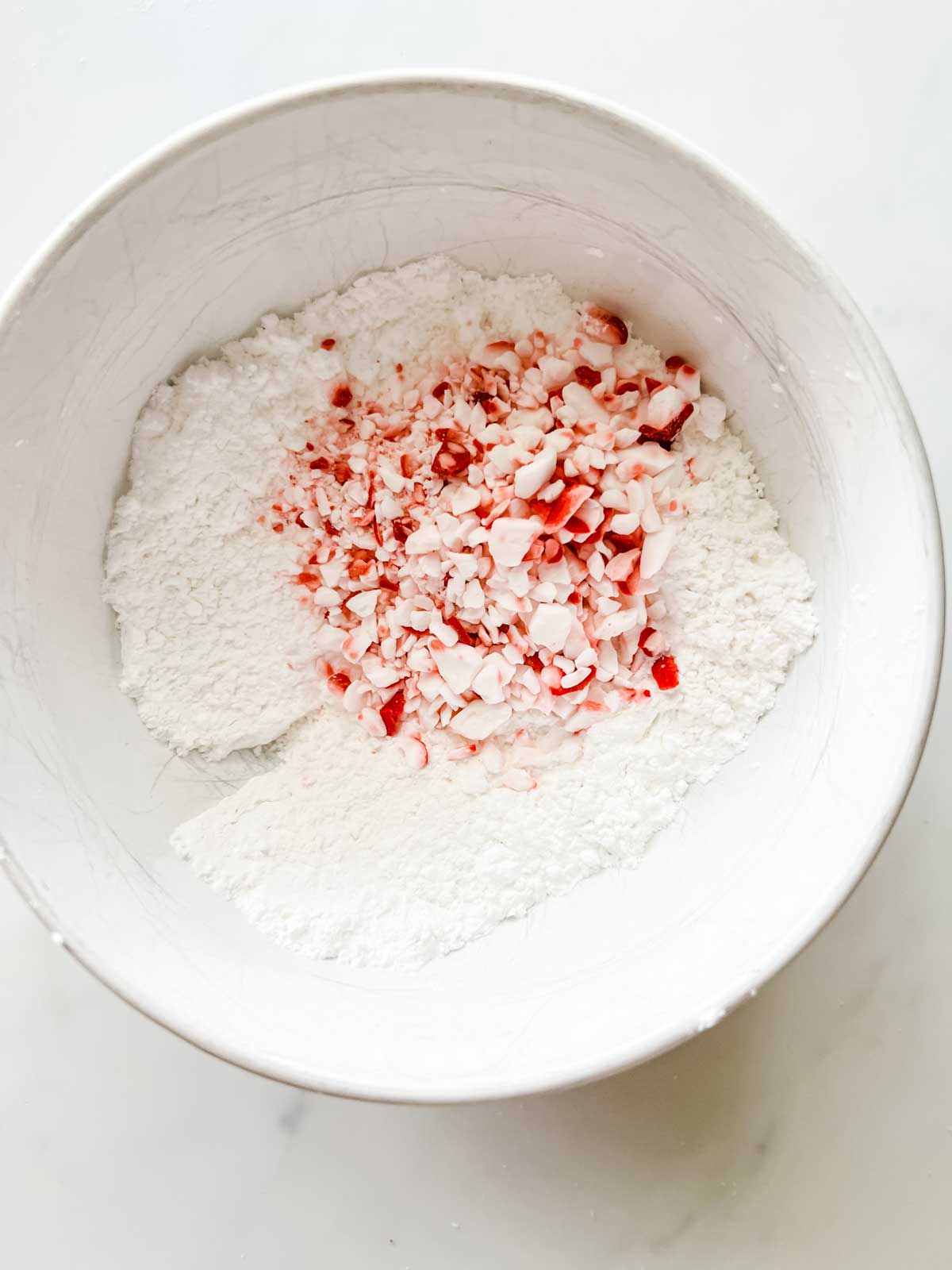 Powdered sugar and crushed peppermint in a white bowl.