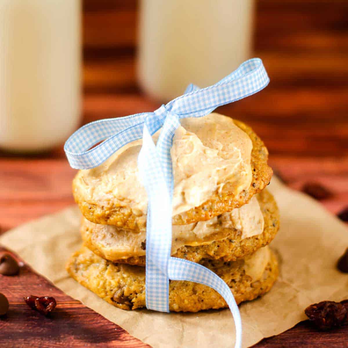 Close up photo of a stack of pumpkin cookies that have been tied together with a ribbon.