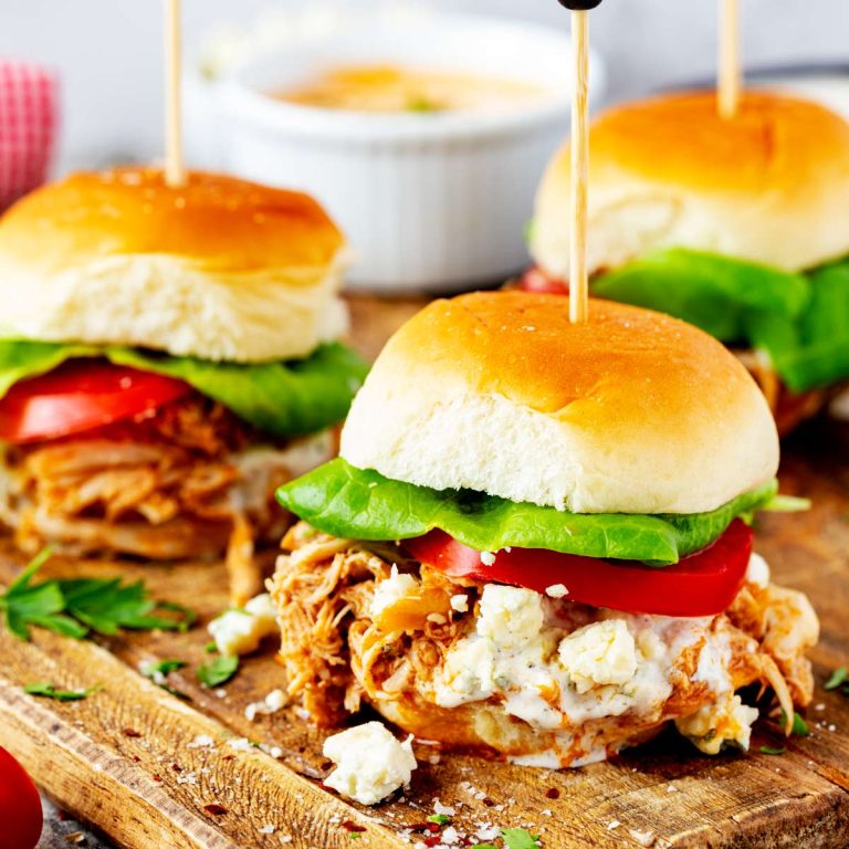 Square side photo of buffalo chicken sliders on a wooden cutting board.