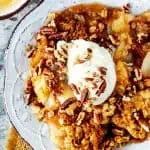 Close up overhead square photo of a pear apple crisp topped with ice cream.