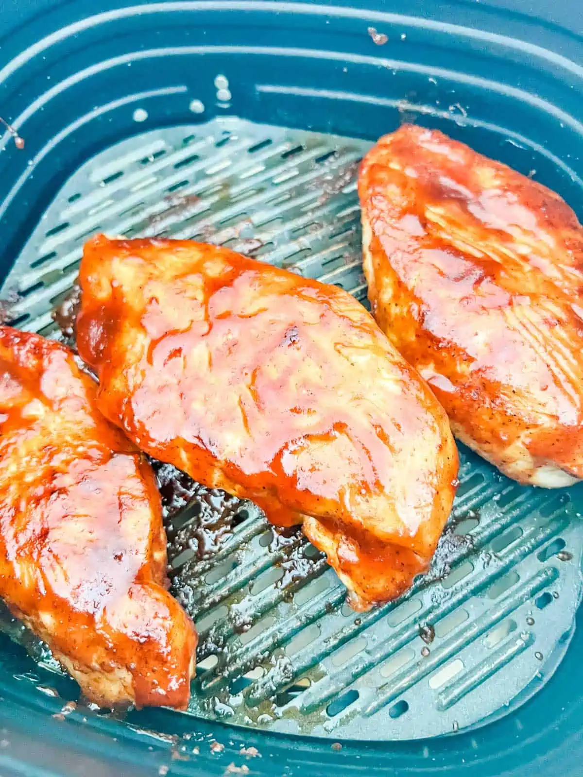 BBQ sauce coated chicken breast in an air fryer.