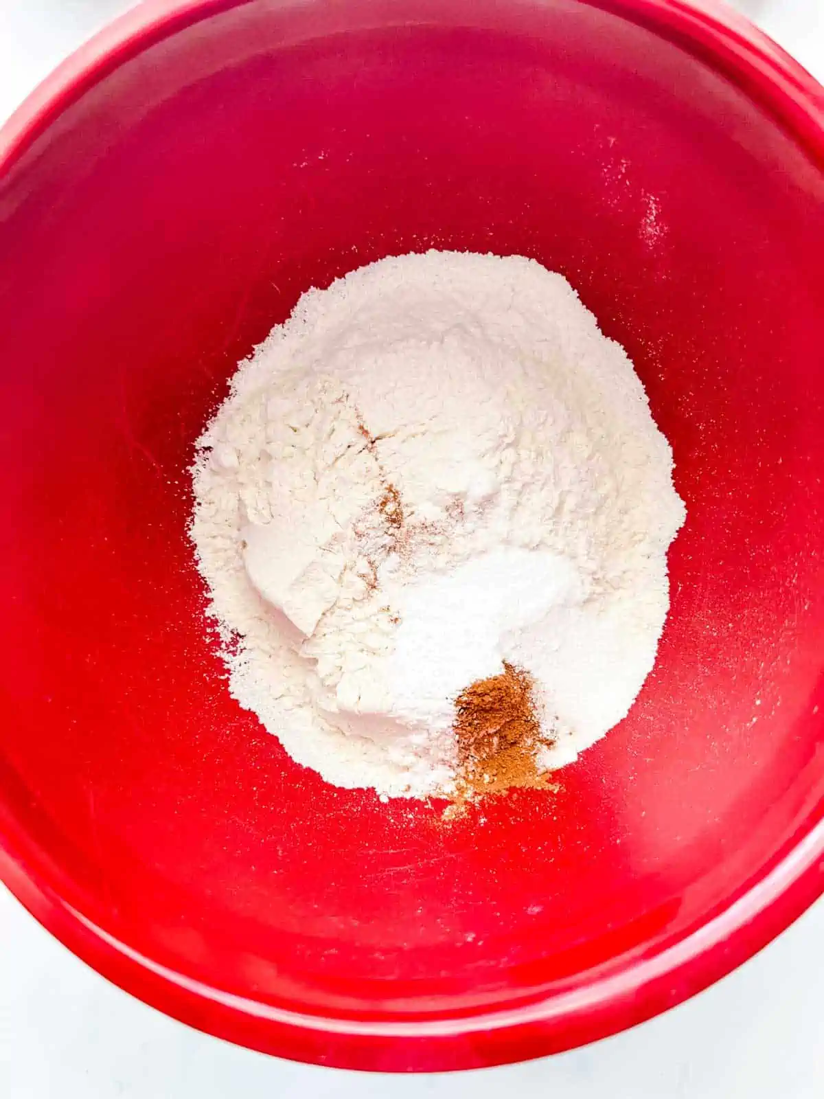 Photo of dry ingredients for cookies in a red bowl.