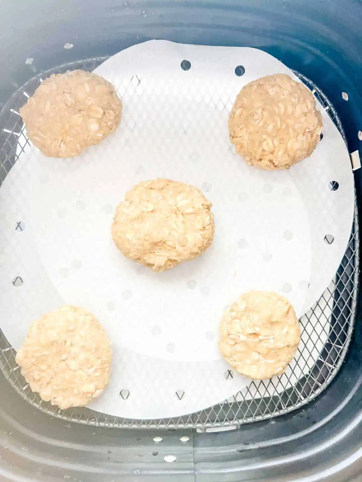 Air fryer basket with cookies ready to cook.