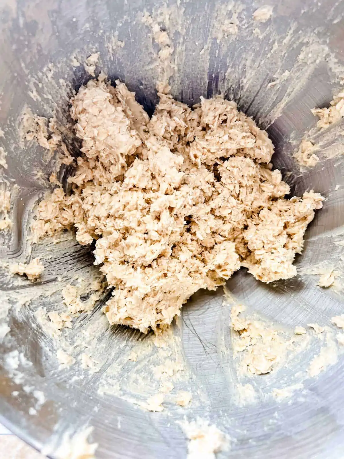 Oatmeal cookie dough in the bowl of a stand mixer.