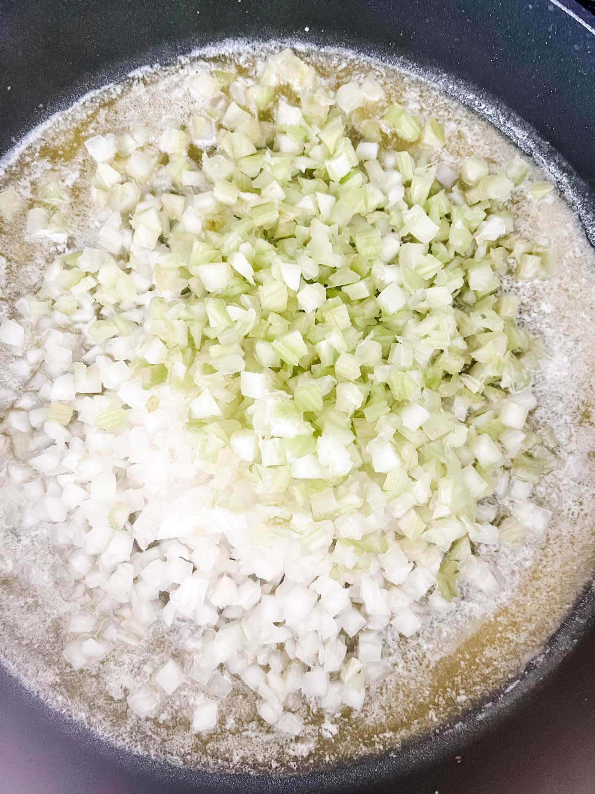 Onion and celery cooking in a pan.