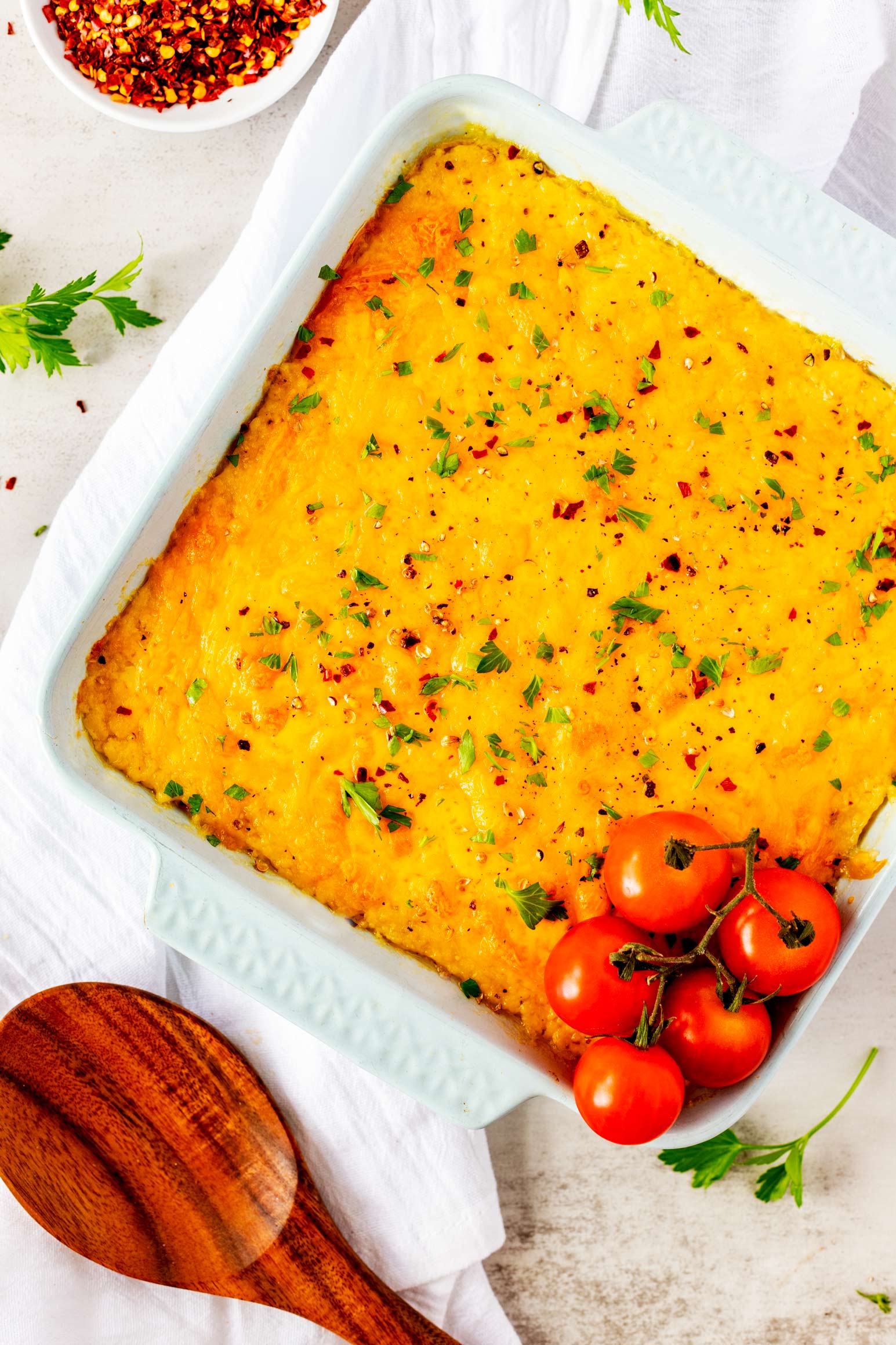 Overhead photo of a white casserole dish with a cheese grits casserole in it.