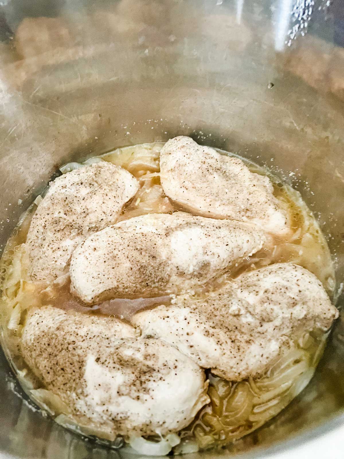 Chicken in a broth that has been cooked in an Instant Pot.