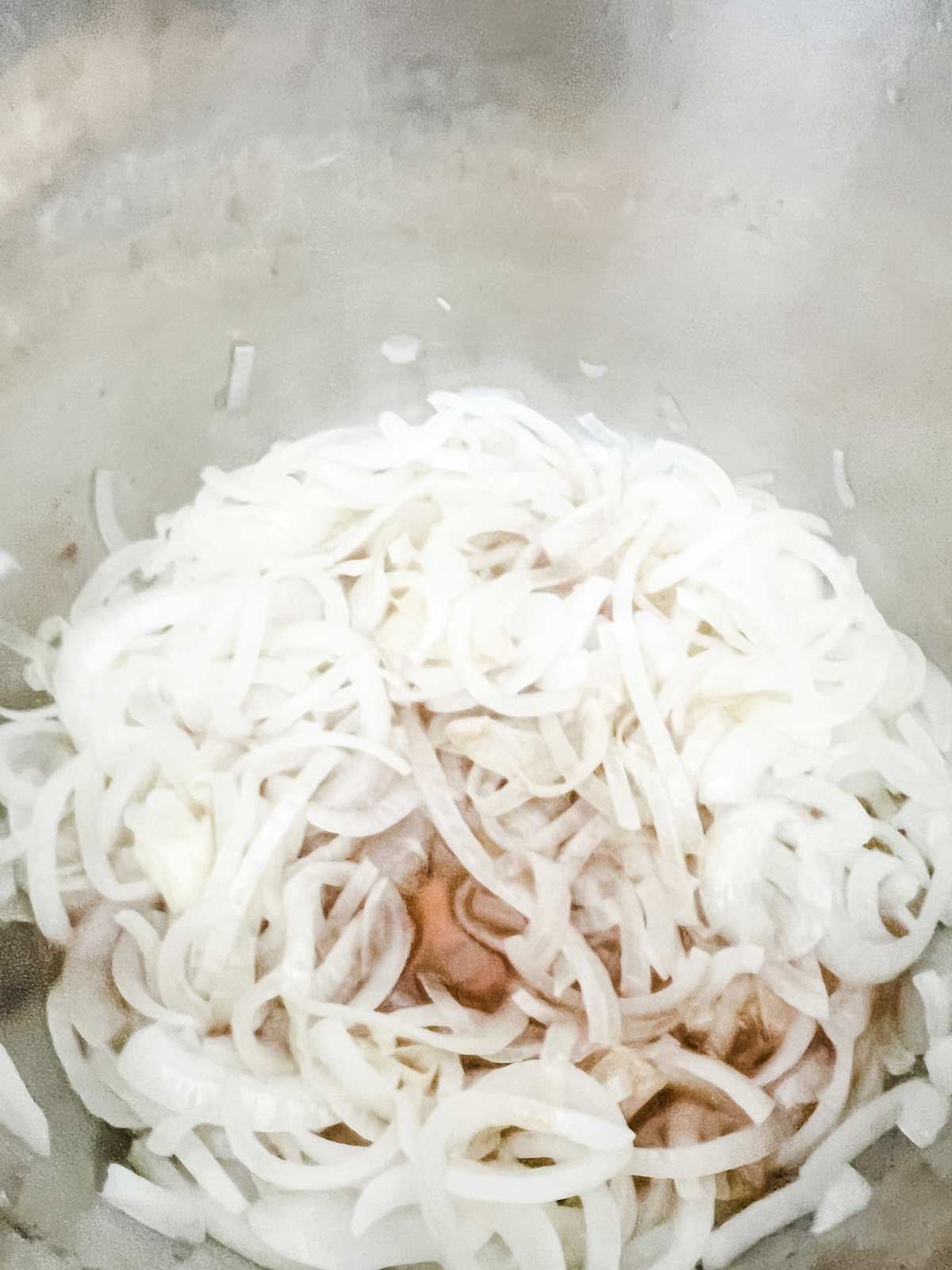 Photo of onions and liquids in an Instant Pot.