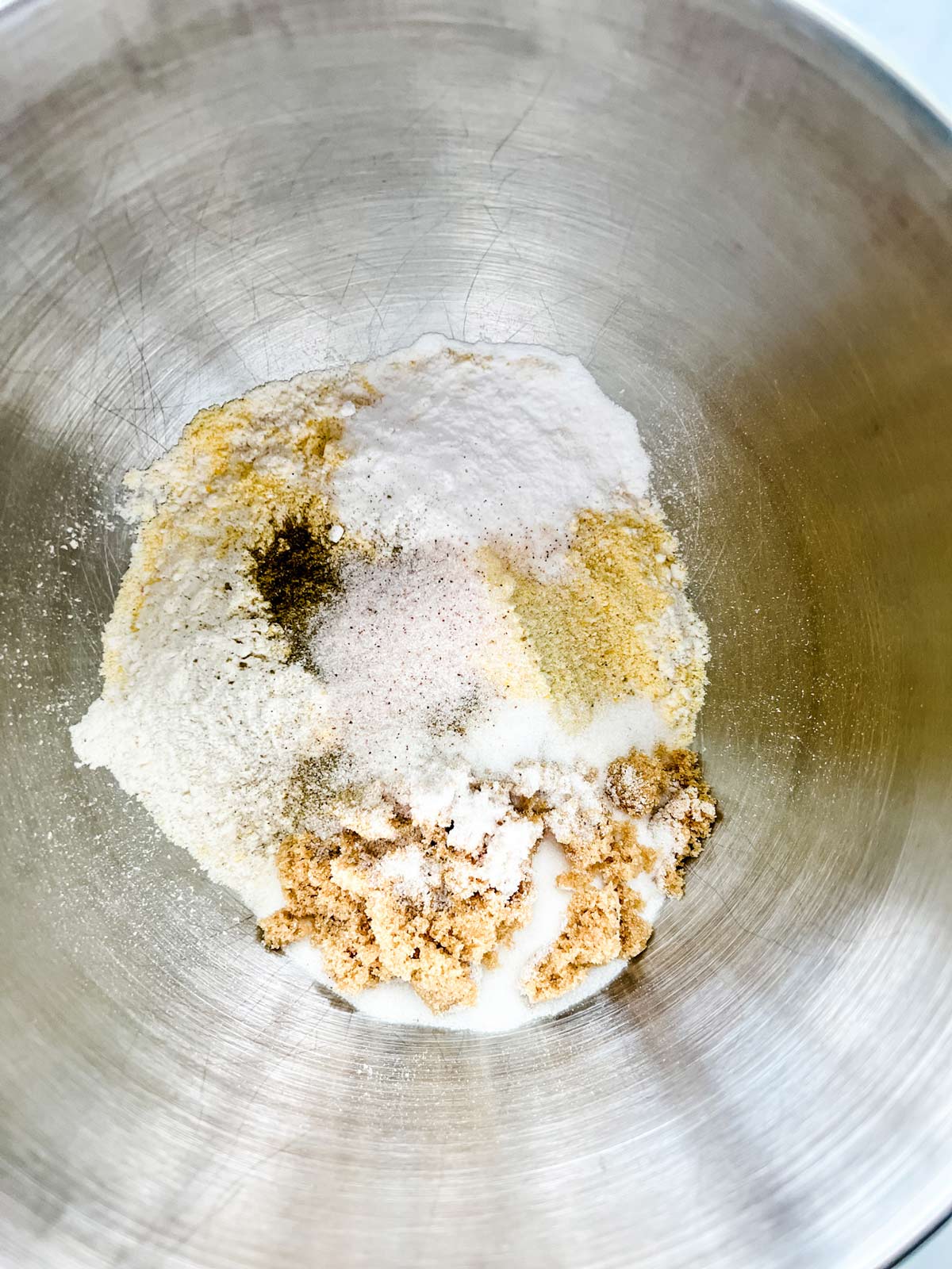 Flour, cornmeal, white sugar, brown sugar, salt, pepper, baking powder, baking soda and seasonings in the bowl of a stand mixer.
