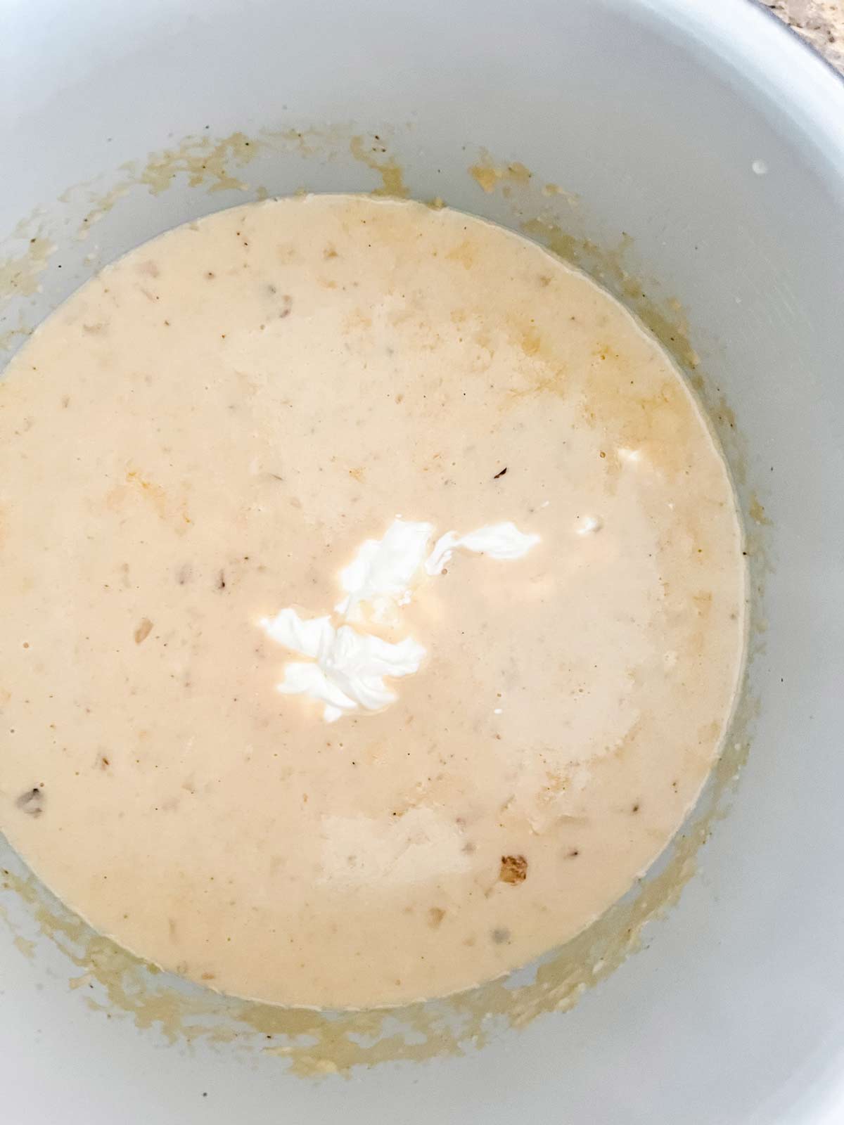 Sour cream being added to potato soup.