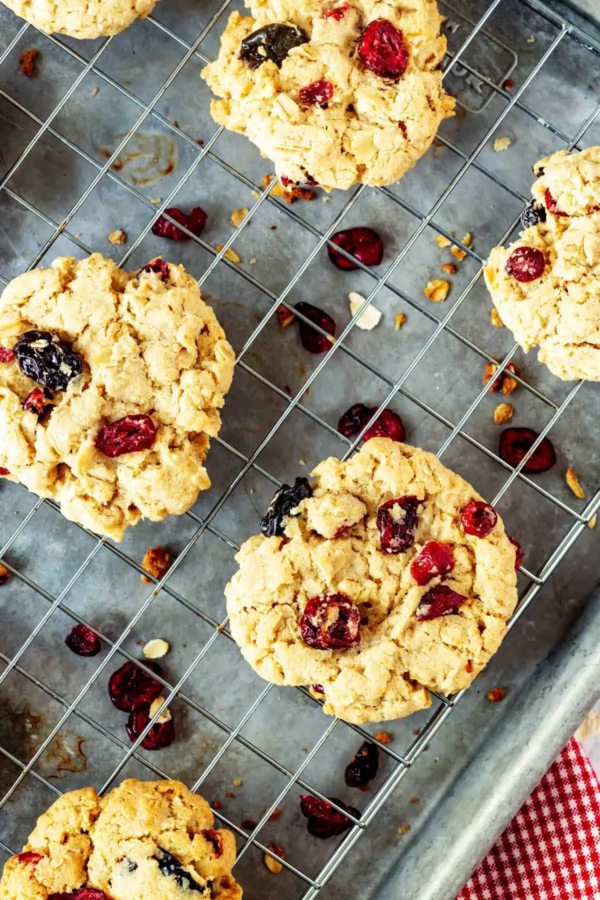 Overhead photo of cranberry oatmeal cookies on a cooling rack set on top of a baking sheet.