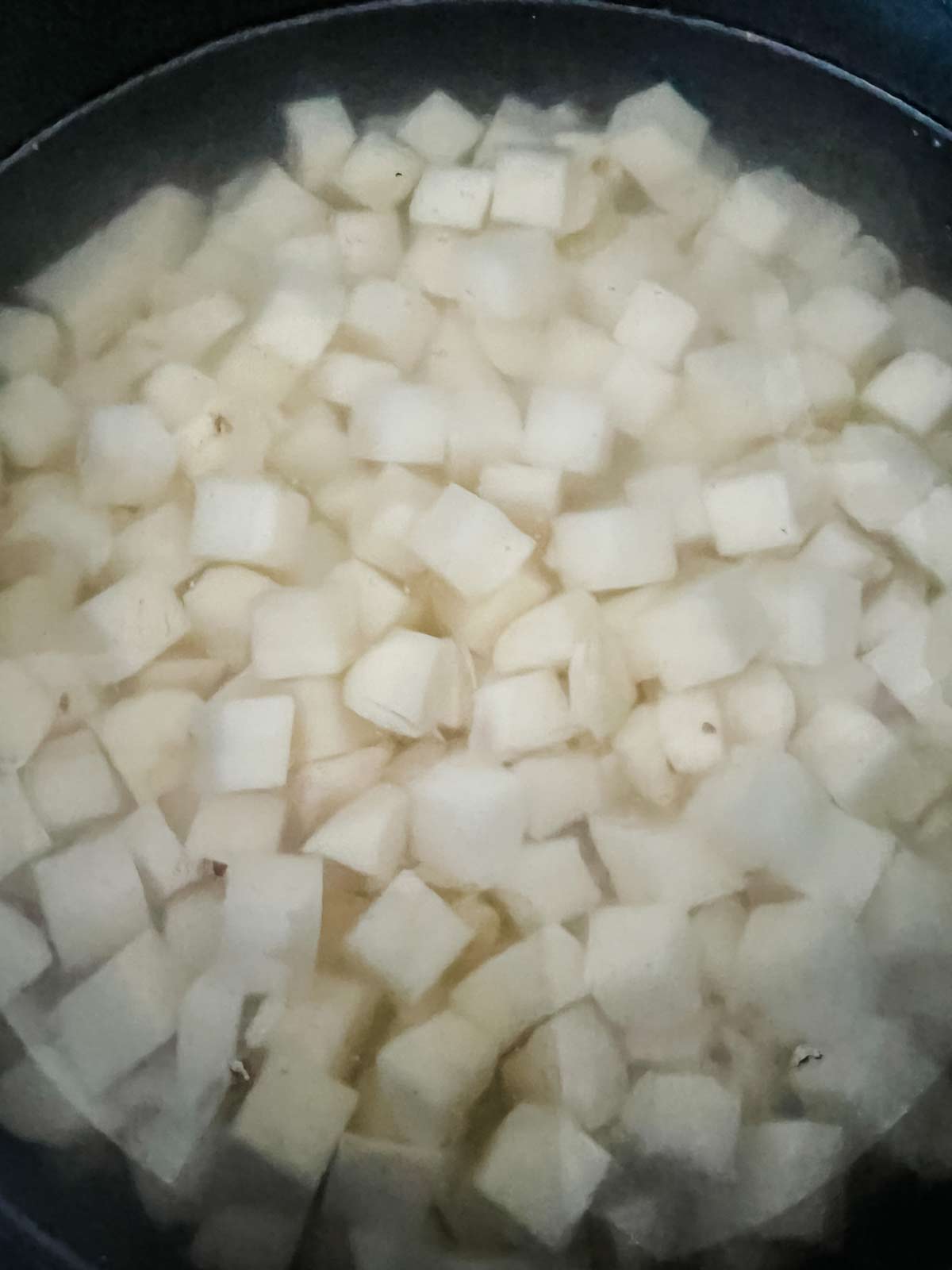 Cubed potatoes in a pot of water.