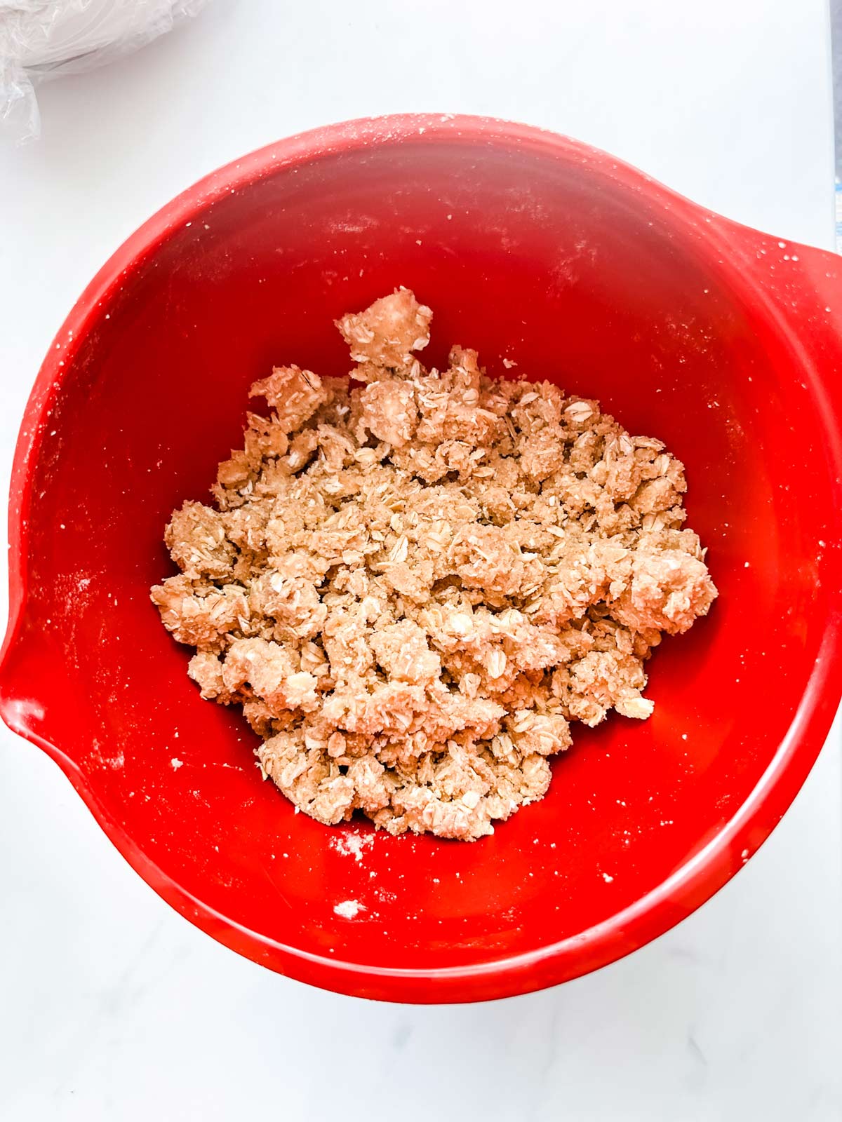 Photo of a crumble topping in a red bowl.