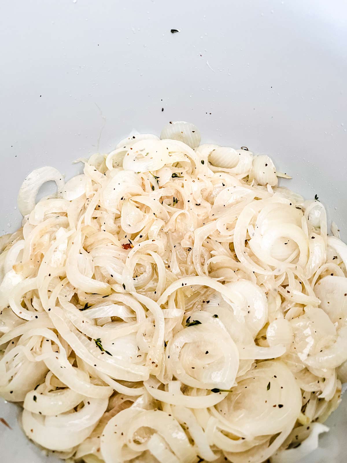 Cooking sherry added to onions in the inner pot of an electric pressure cooker.