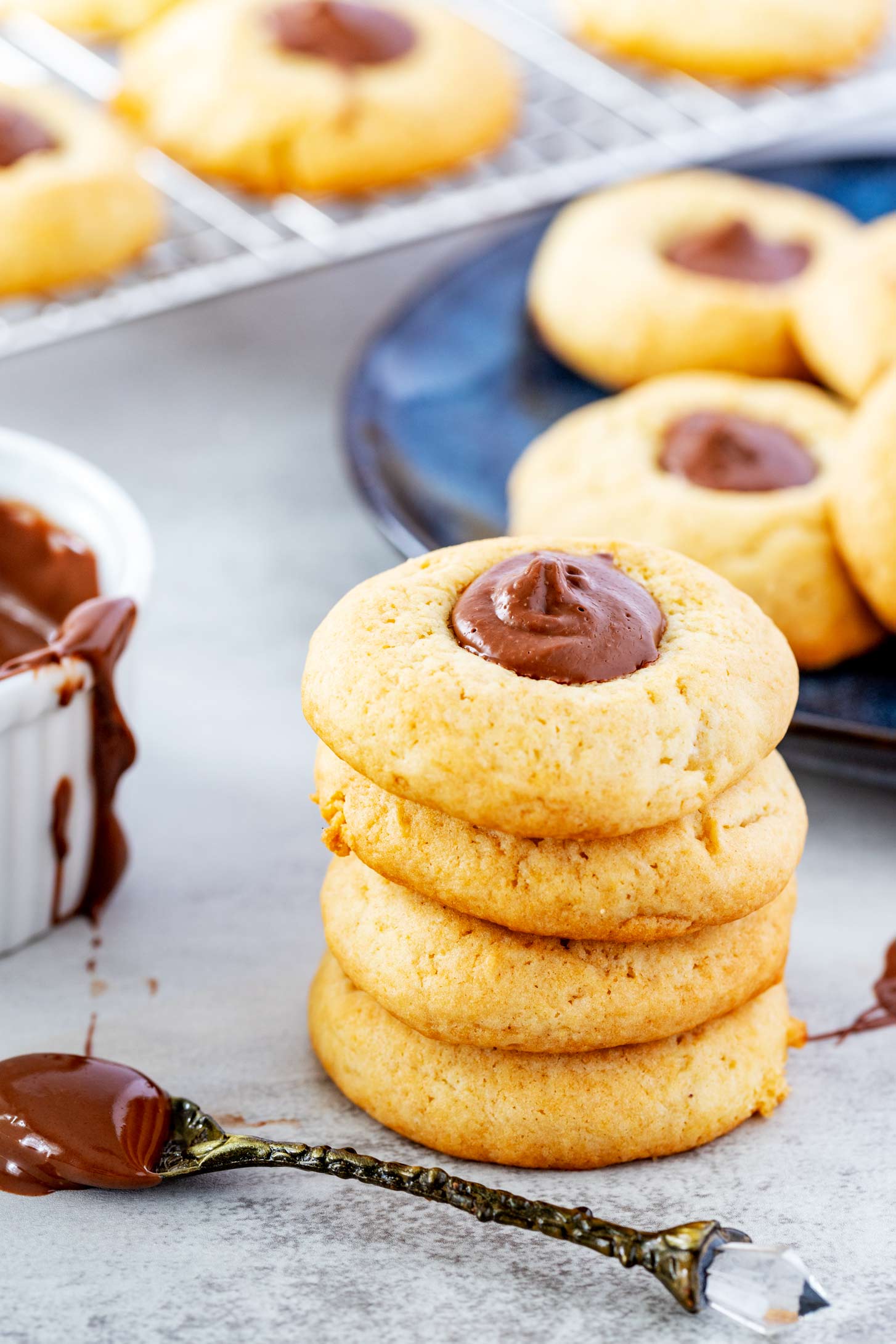 Photo of four stacked nutella thumbprint cookies.
