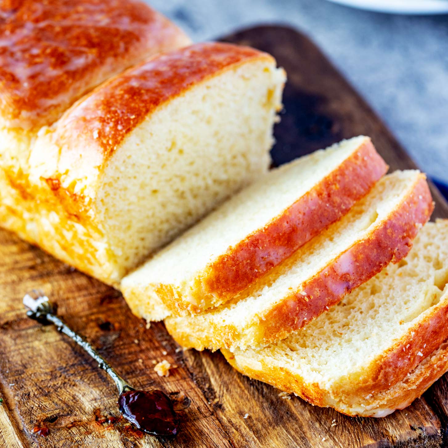 Square photo of partially sliced brioche bread.