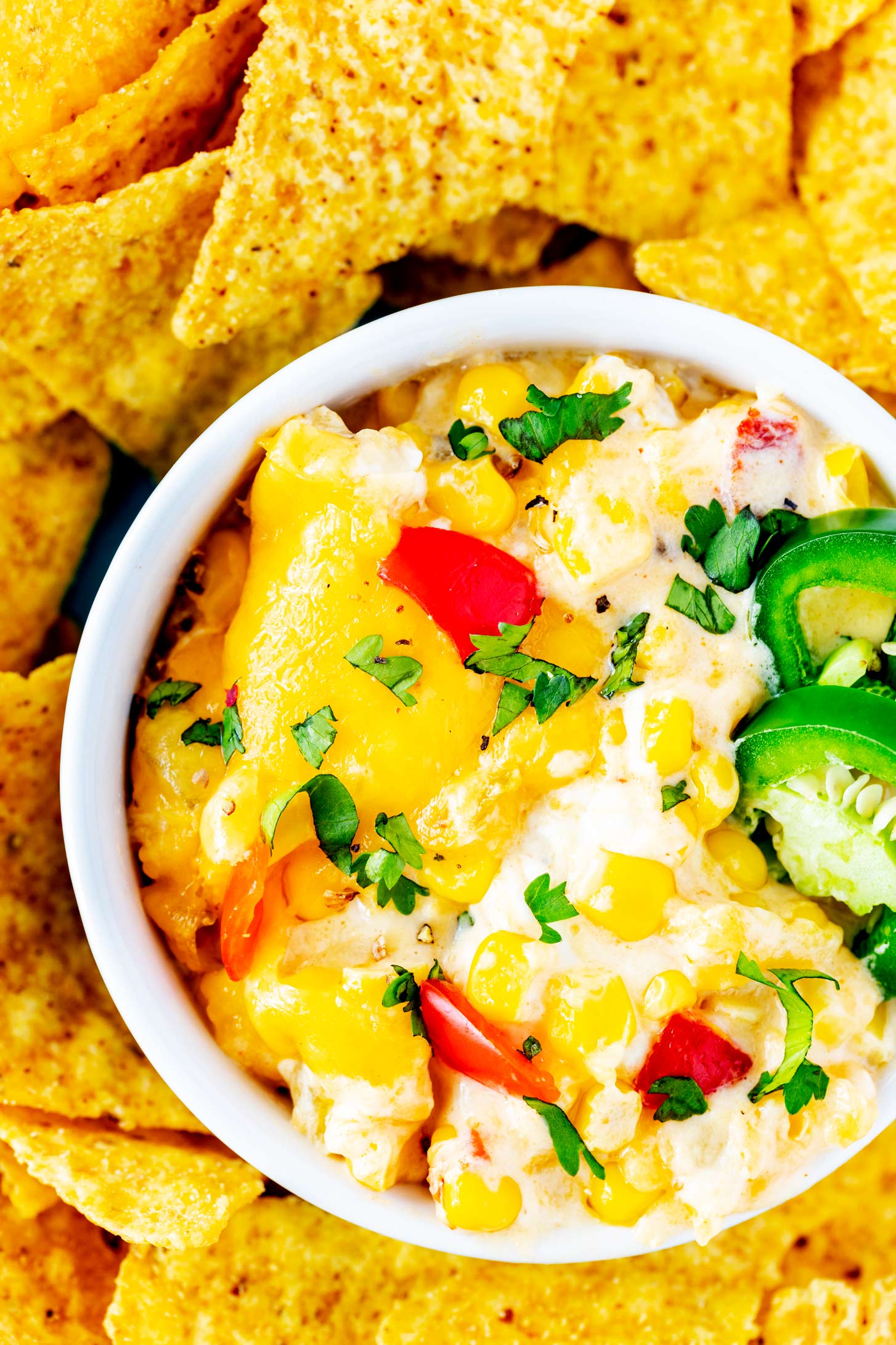 Overhead photo of a crock of corn dip surrounded by tortilla chips.