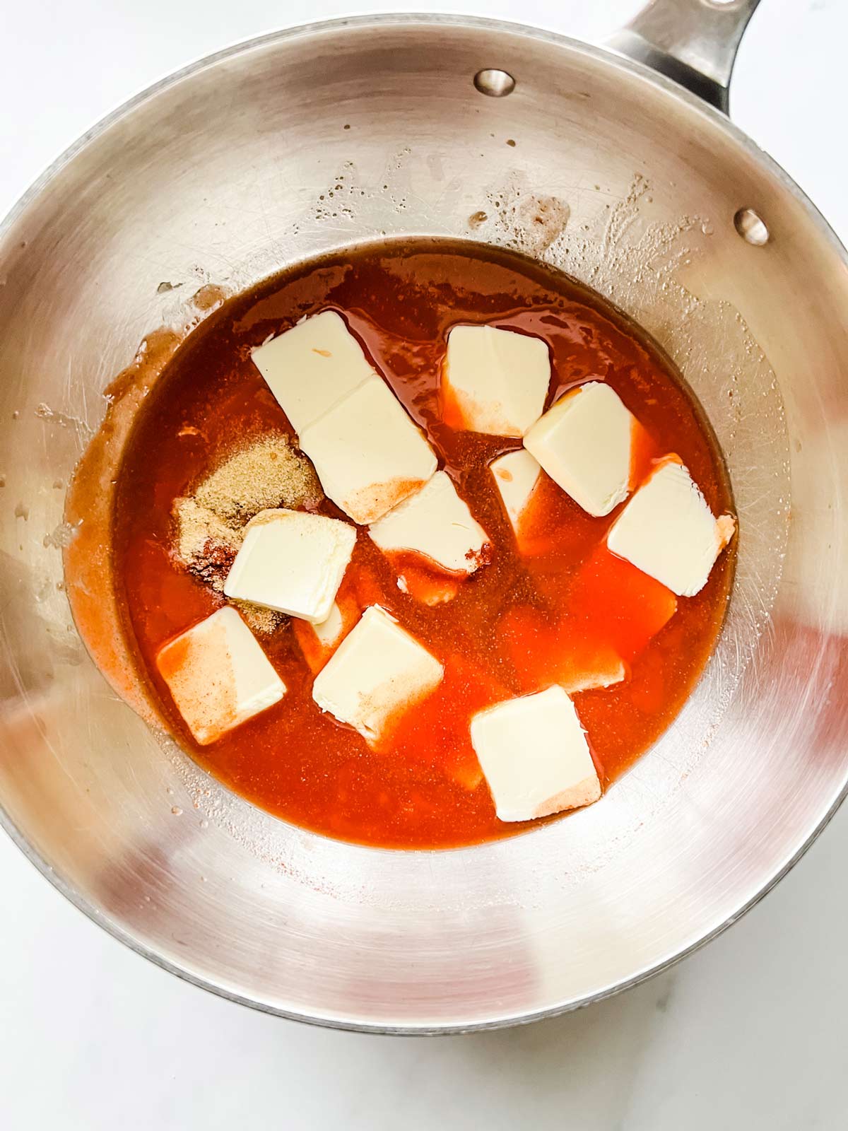 Photo of a saucepan with the ingredients for homemade buffalo sauce in it ready to be heated.