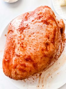 Photo of a raw seasoned turkey breast.