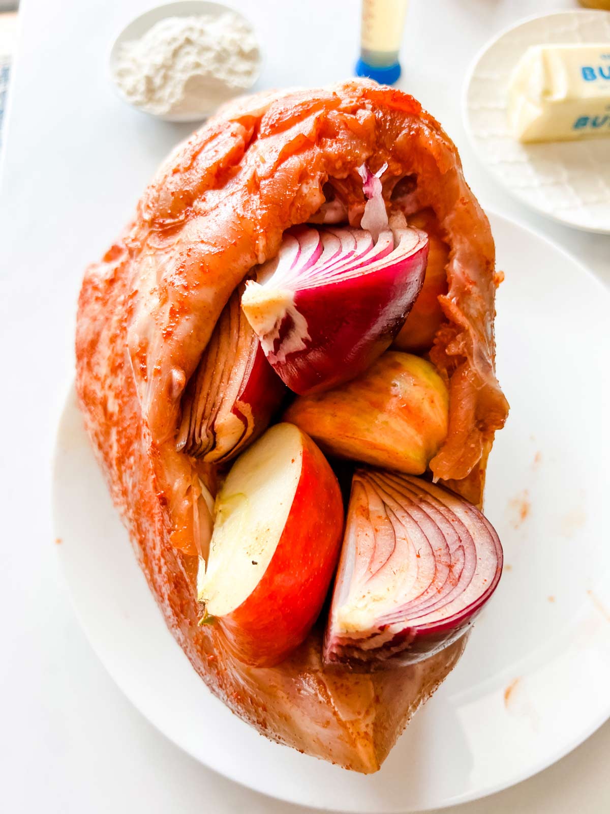 Photo of a raw turkey breast stuffed with onion and apple.