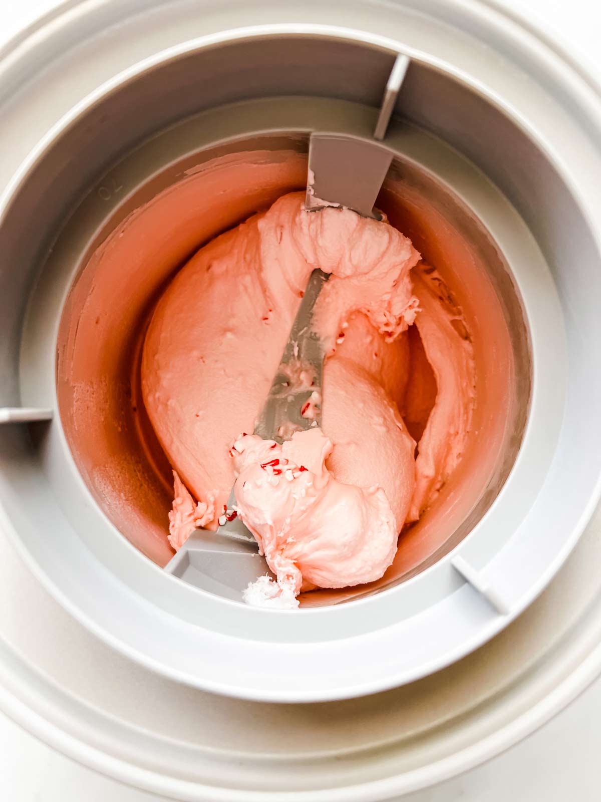 Peppermint ice cream churning in an ice cream maker.