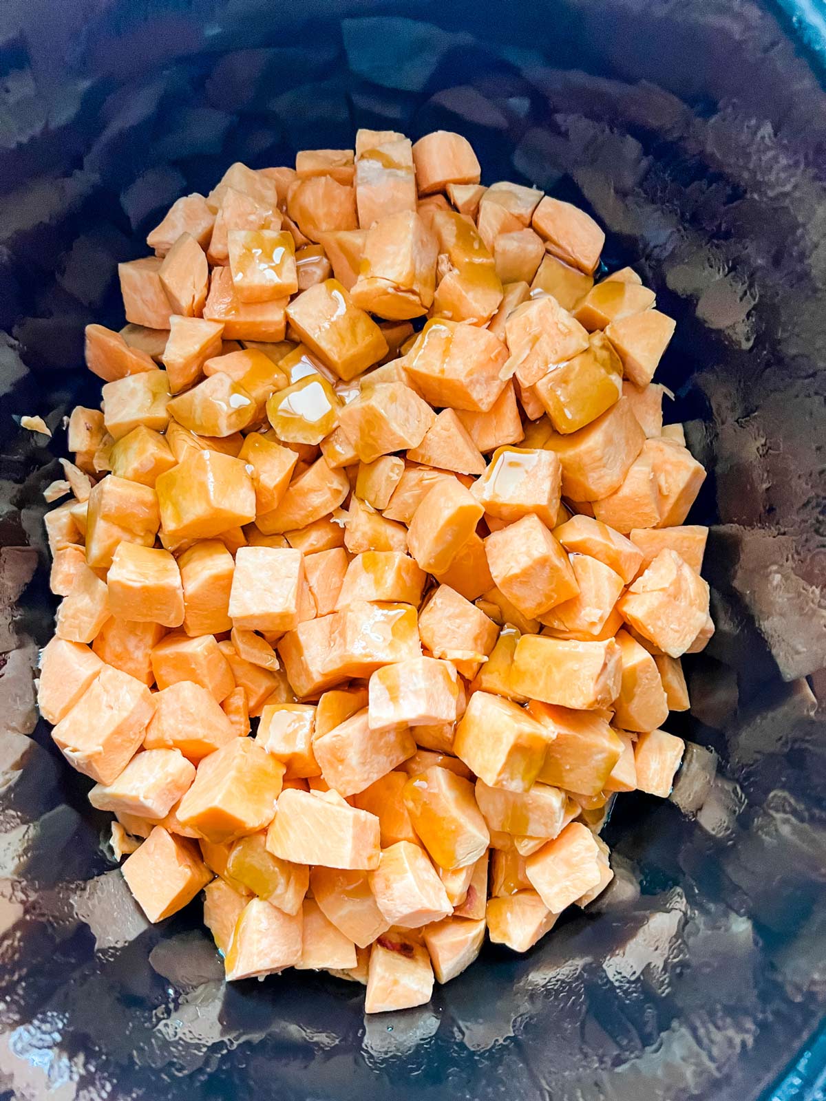 Cubed sweet potatoes in a slow cooker.