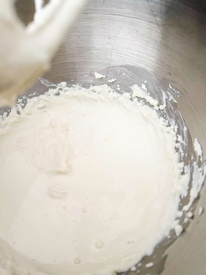 Photo of whipped ricotta cheese in the bowl of a stand mixer.