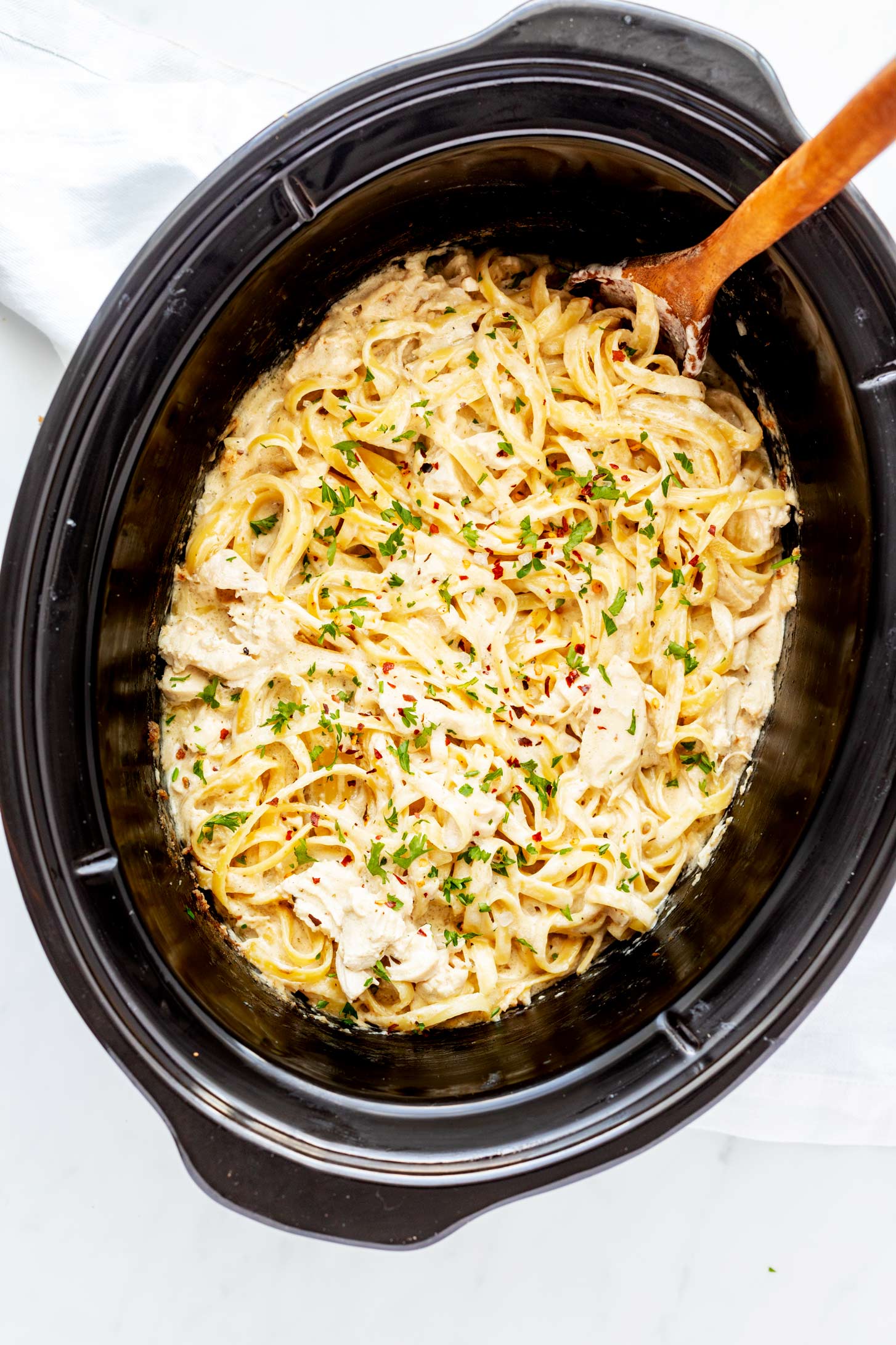 Overhead photo of chicken alfredo in a slow cooker.