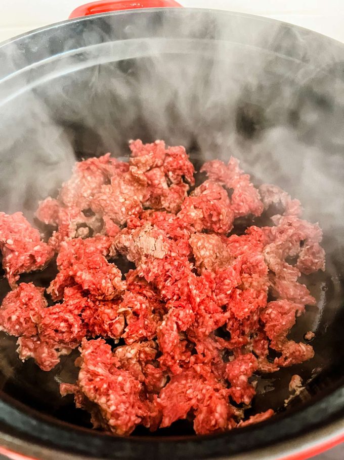 Ground beef cooking on the saute function of a slow cooker.
