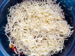 A top layer of cheese that has been added to crockpot ravioli lasagna.
