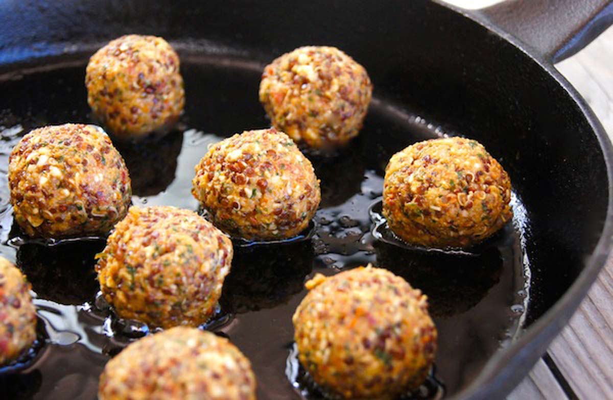 Photo of quinoa balls cooking in a skillet.