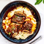 Square overhead photo of a blue bowl with Instant Pot Short Ribs.