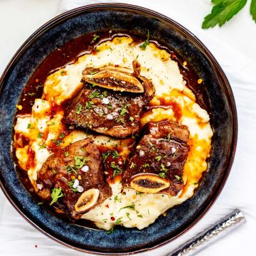 Square overhead photo of a blue bowl with Instant Pot Short Ribs.