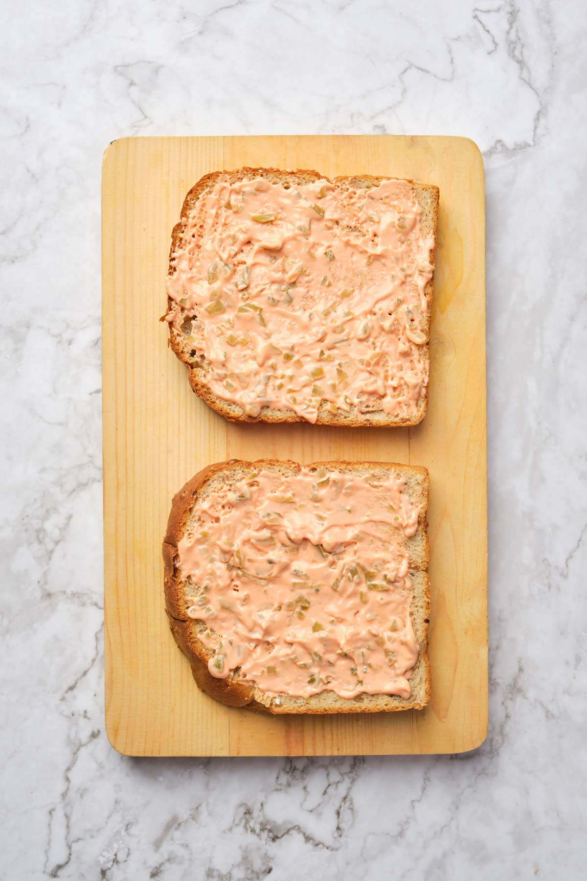 Photo of a Russian-style dressing spread on two pieces of bread. 