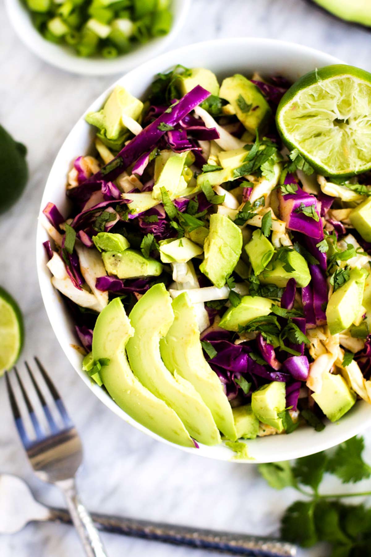 Close up photo of a white bowl with cilantro lime slaw.