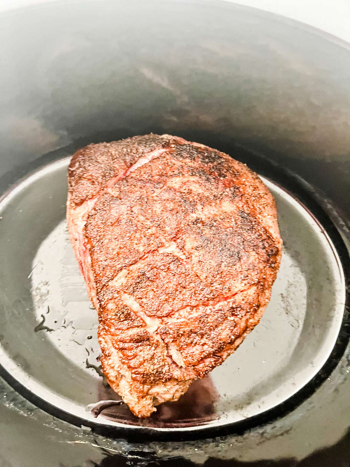 A seared roast in a slow cooker.