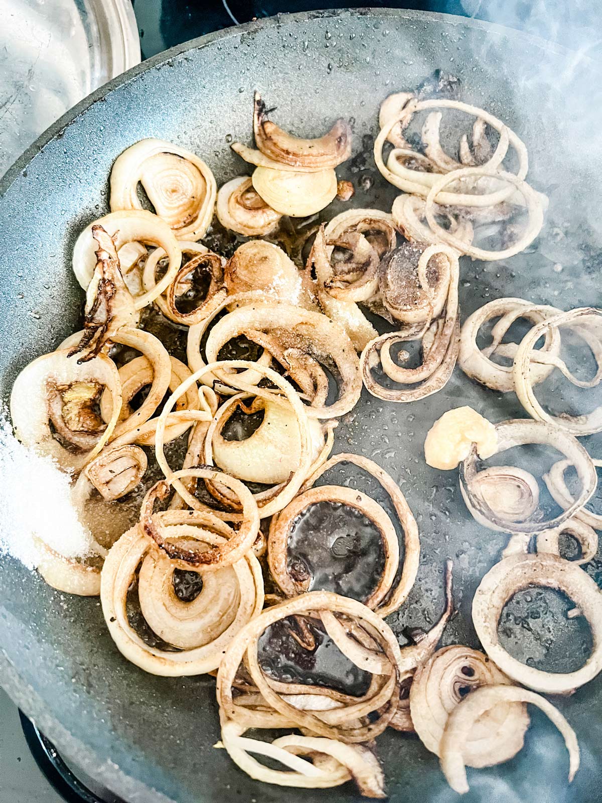 Onions cooking on a skillet.