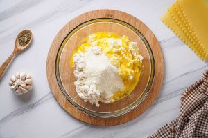 Ricotta cheese, egg, and parmesan in a bowl.