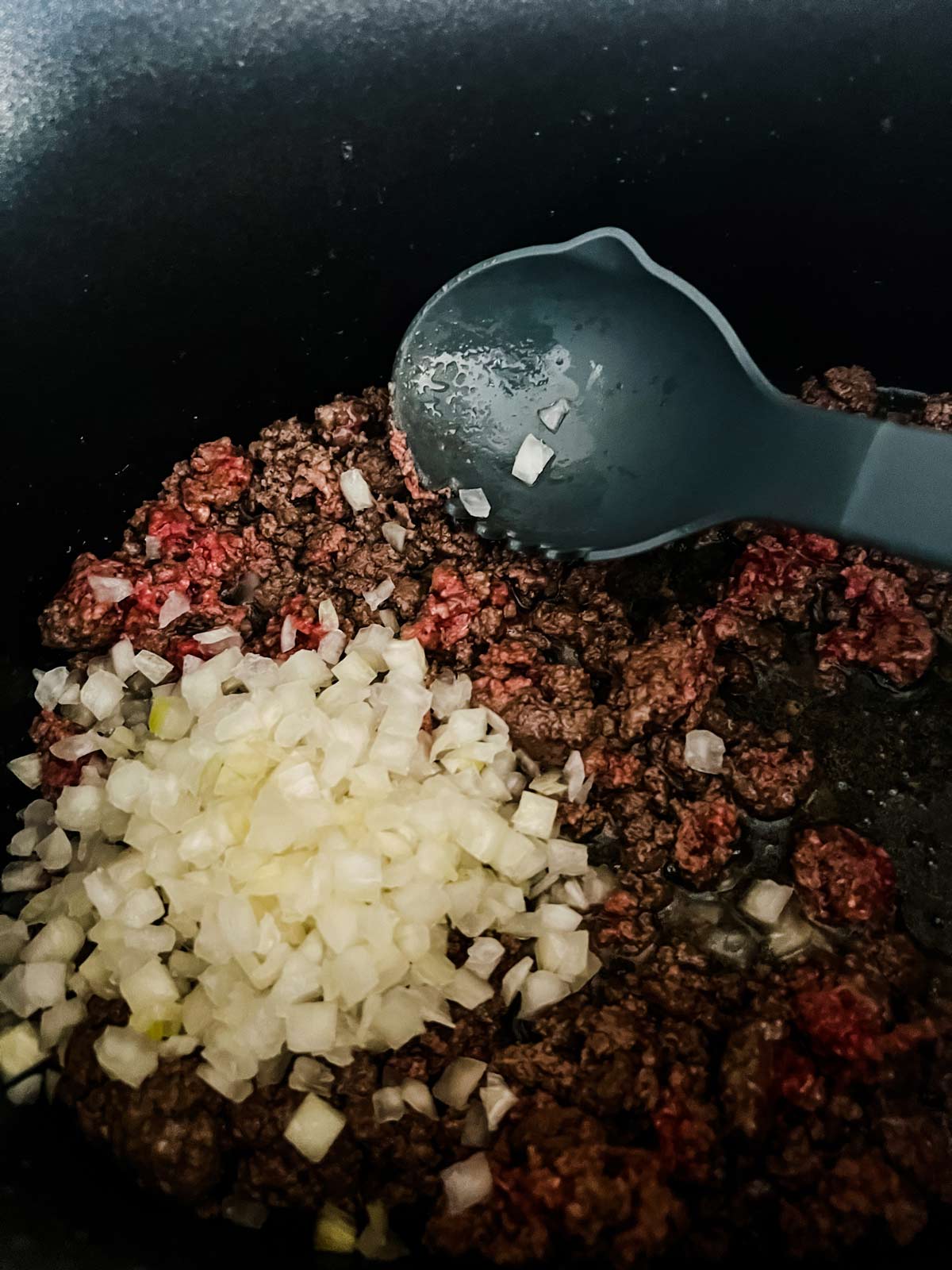 Onion added to partially browned ground beef.