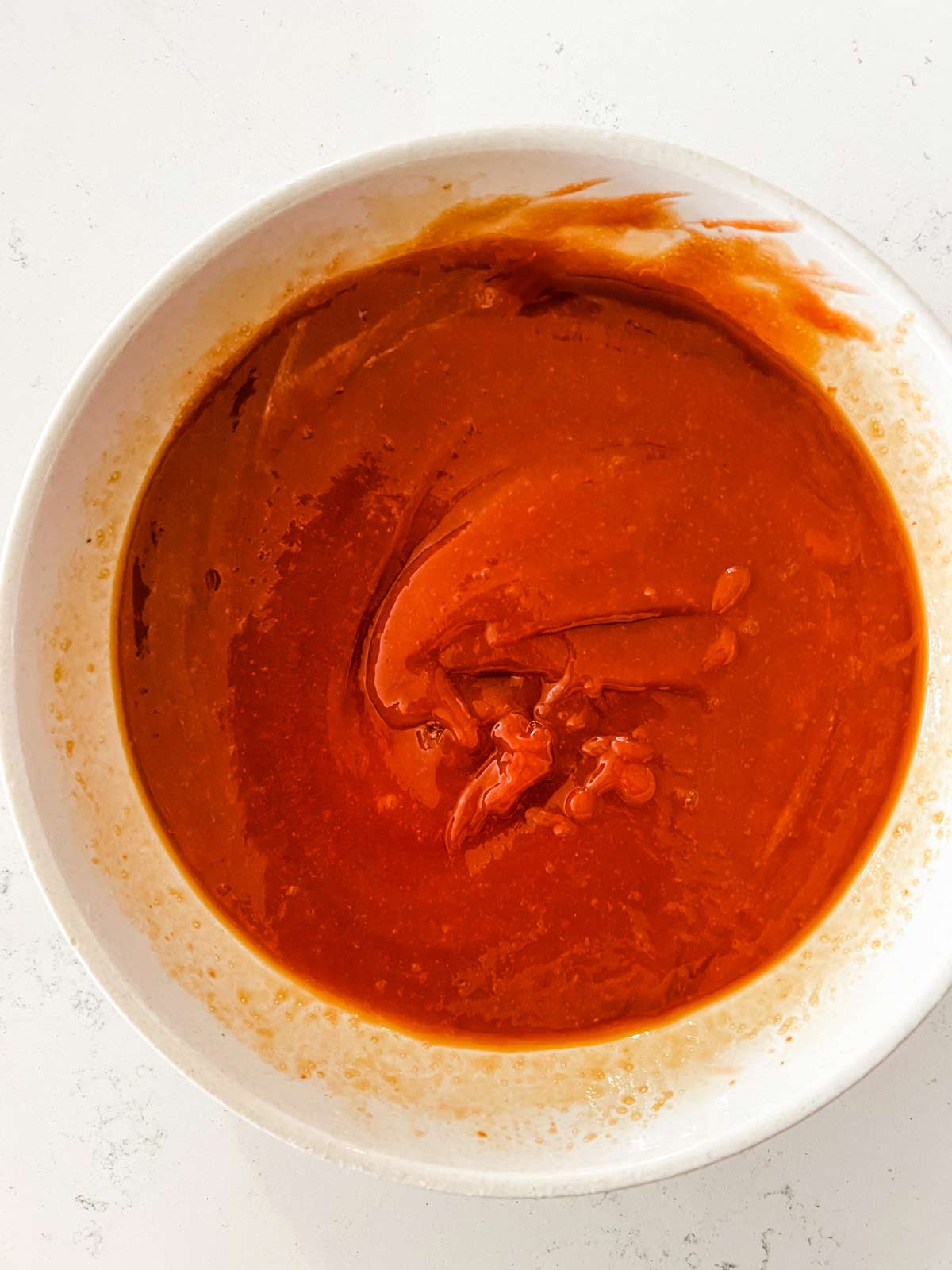 Ketchup, brown sugar, soy sauce, and mustard that have been mixed together in a small bowl