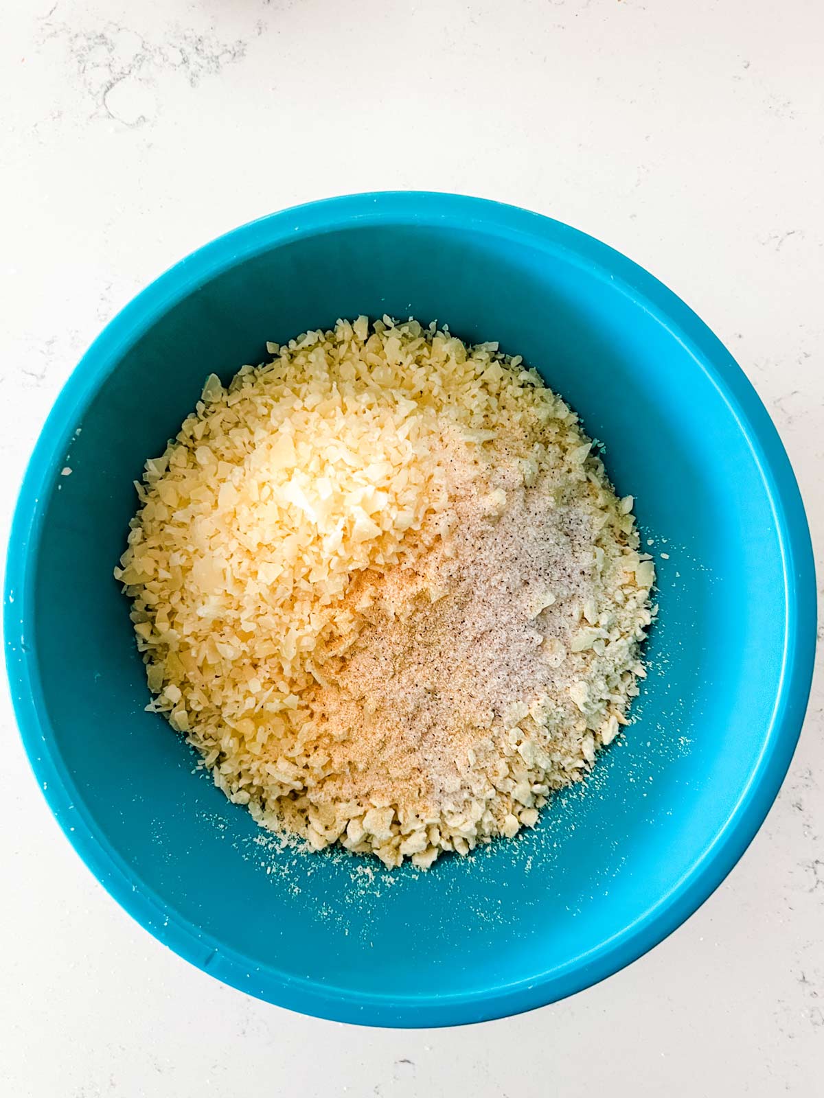 Crushed saltine crackers, parmesan, garlic powder, and salt in a mixing bowl.