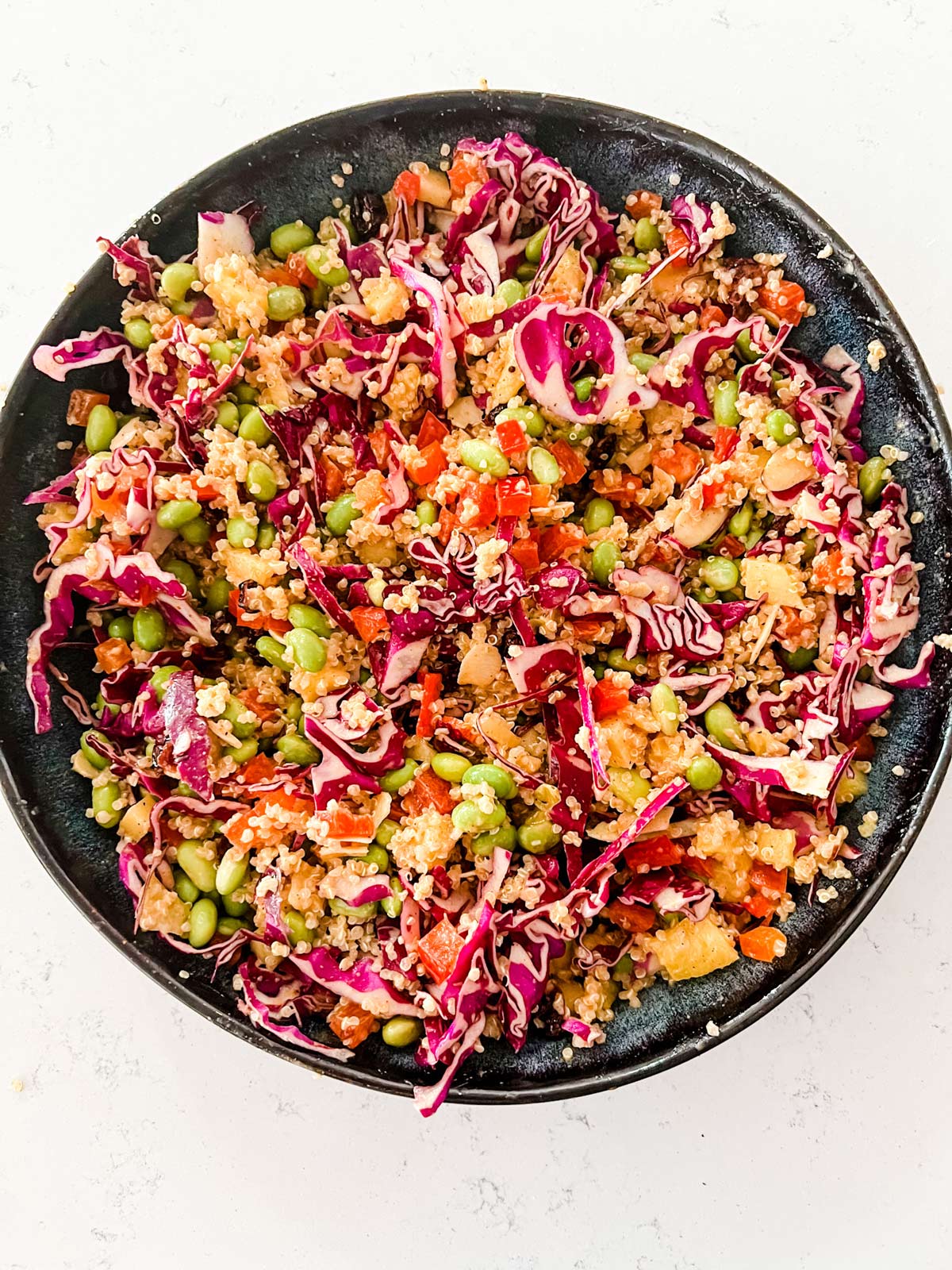 A mixed edamame quinoa salad in a blue bowl.