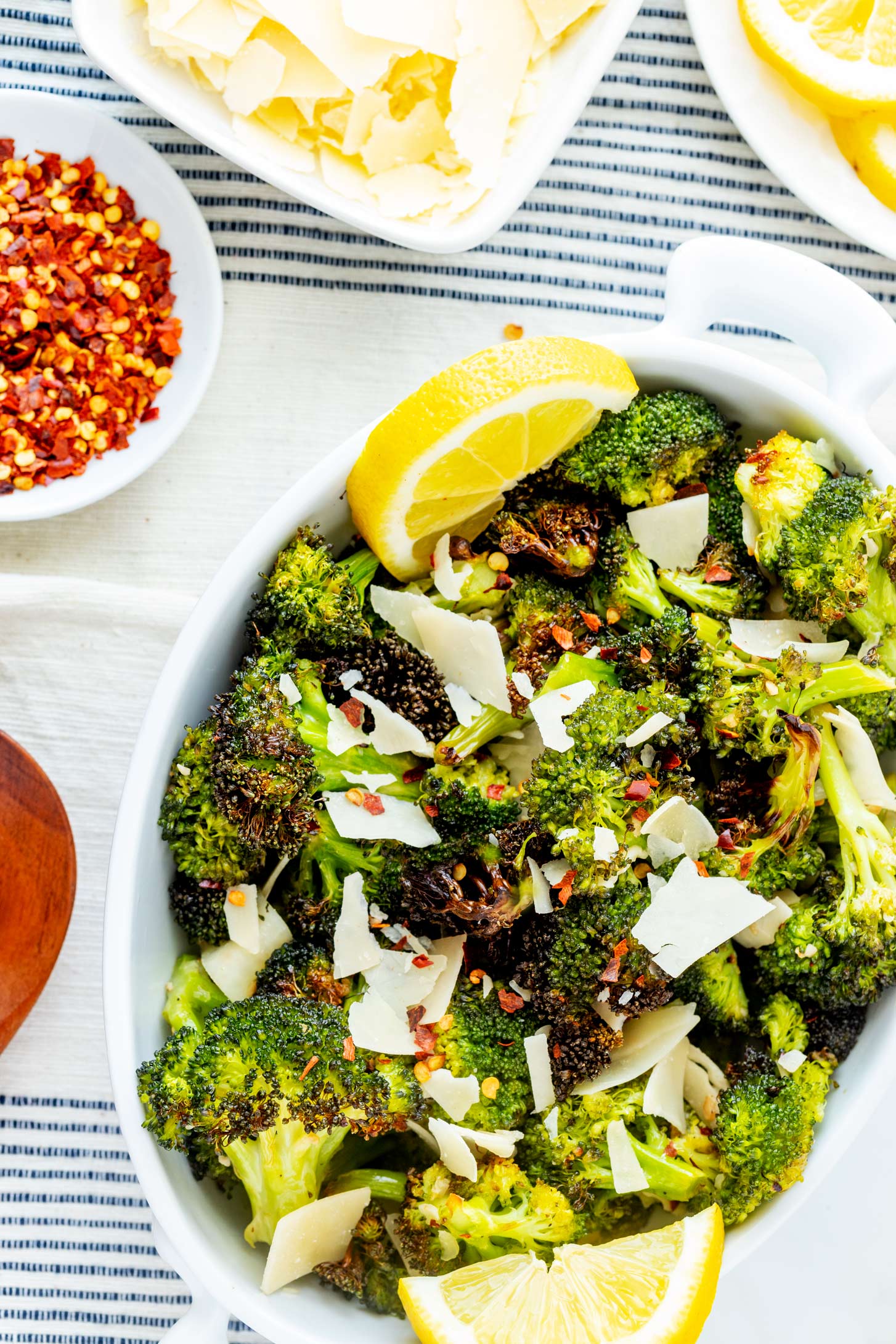 Close up overhead photo of a white serving dish with garlic roasted broccoli.