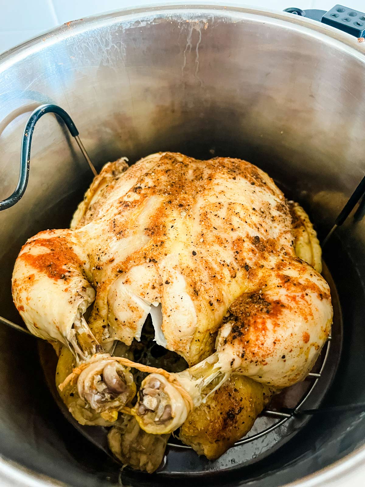 A cooked whole chicken in an Instant Pot.