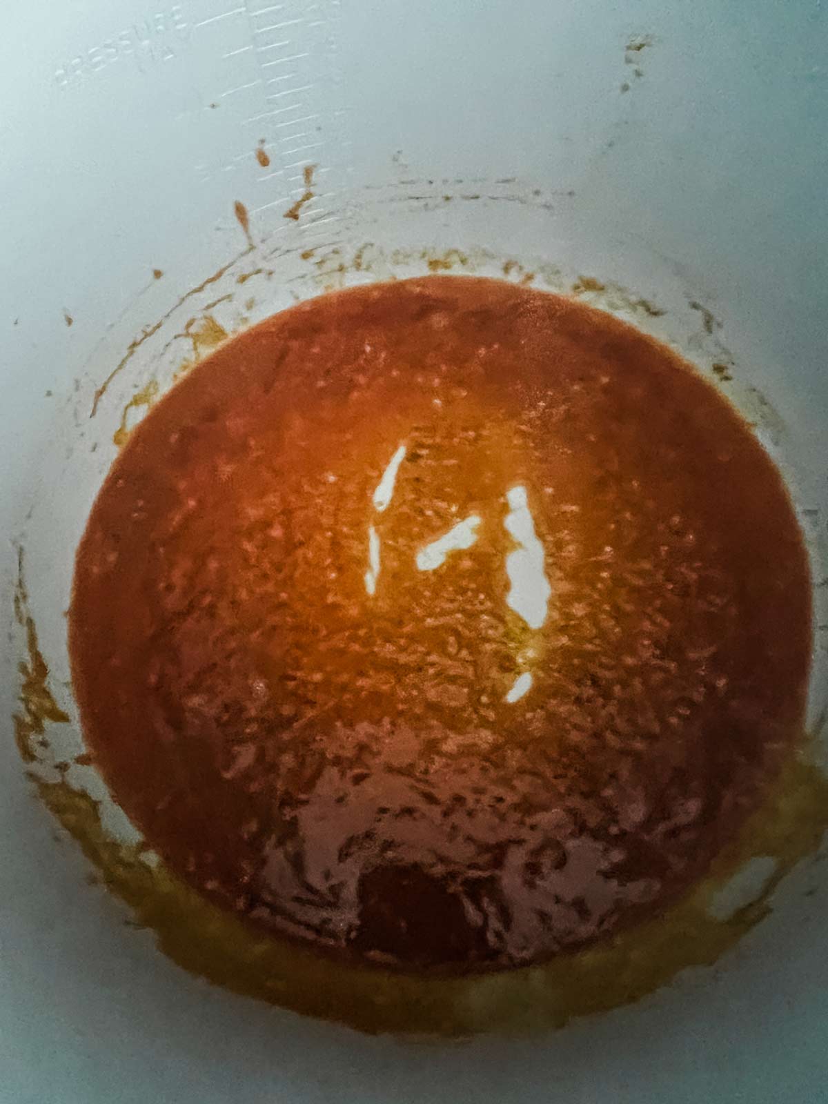 A hot sauce mixture cooking in the inner pot for a Ninja Foodi.