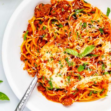 Overhead photo of Ninja Foodi spaghetti in a white bowl garnished with basil.